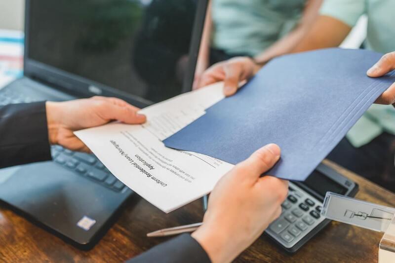 Deux hommes échangent un dossier d'assurance de loyers impayés